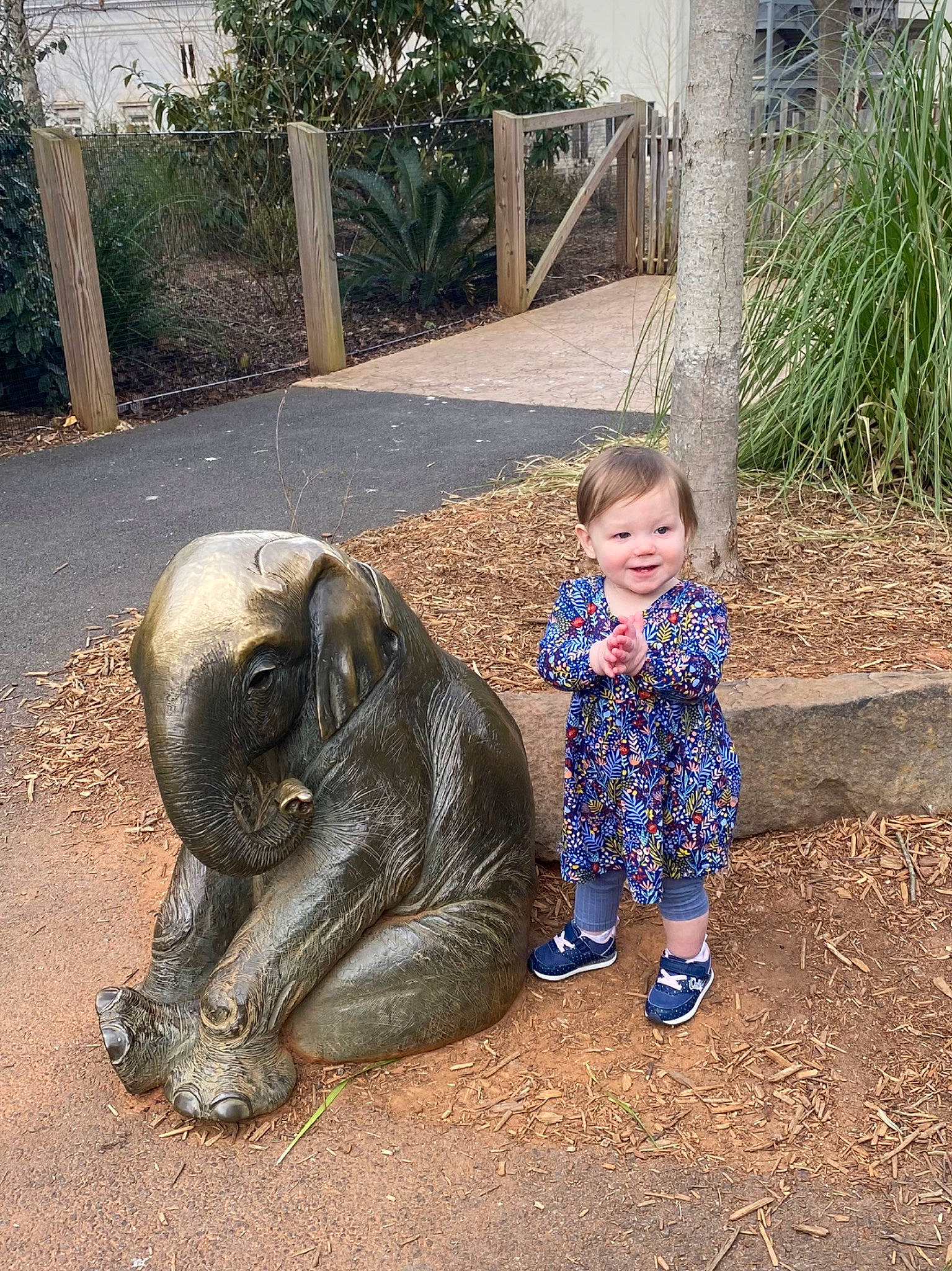 Millie joined the competition — help win amazing prizes! art, baby_toddler_clothing, child, fence, fun, grass, indian_elephant, joy, lawn_ornament, leisure, person, plant, recreation, sculpture, sitting, snout, soil, statue, terrestrial_animal, toddler