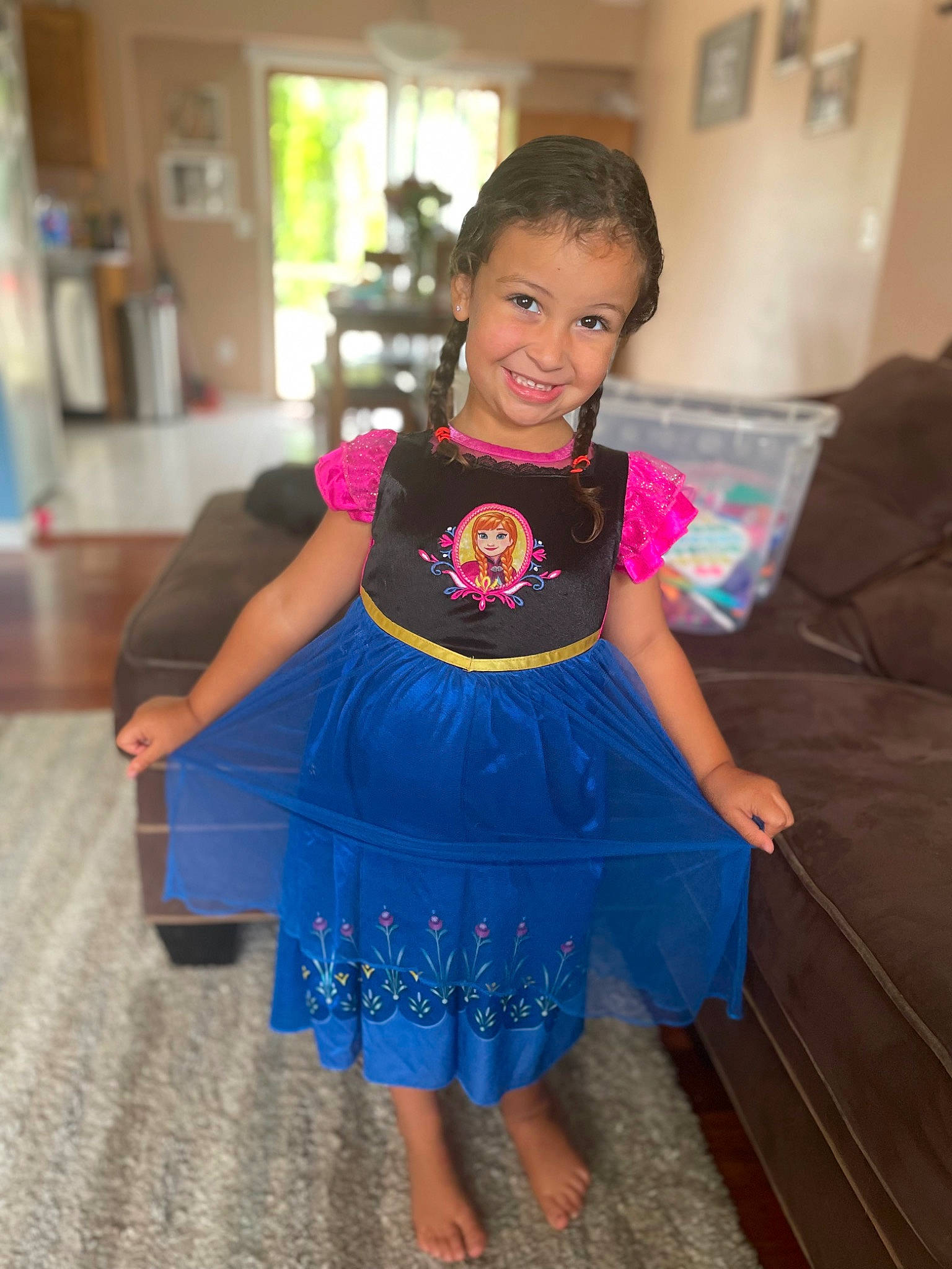 Juliana is registered to the contest to win money with this photo: baby_toddler_clothing, couch, day_dress, dress, electric_blue, fashion_design, flooring, fun, happy, human_body, joy, long_hair, neck, one_piece_garment, person, shoulder, sleeve, smile, thigh, toddler