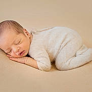 Isaac participe au concours pour gagner de l'argent avec cette photo : baby, newborn, sleeping, infant, soft, blanket, beige, cozy, cute, child, peaceful, portrait, rest, comfort, small, sleep, face, clothing, hands, lying_down