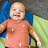 Levi joined the competition — help win amazing prizes! baby, smiling, infant, cactus_pattern, orange_shirt, black_pants, colorful_mat, blue, green, brown, carpet, happy, cute, child, portrait, lying_down, indoor, casual_clothing, cheerful, young