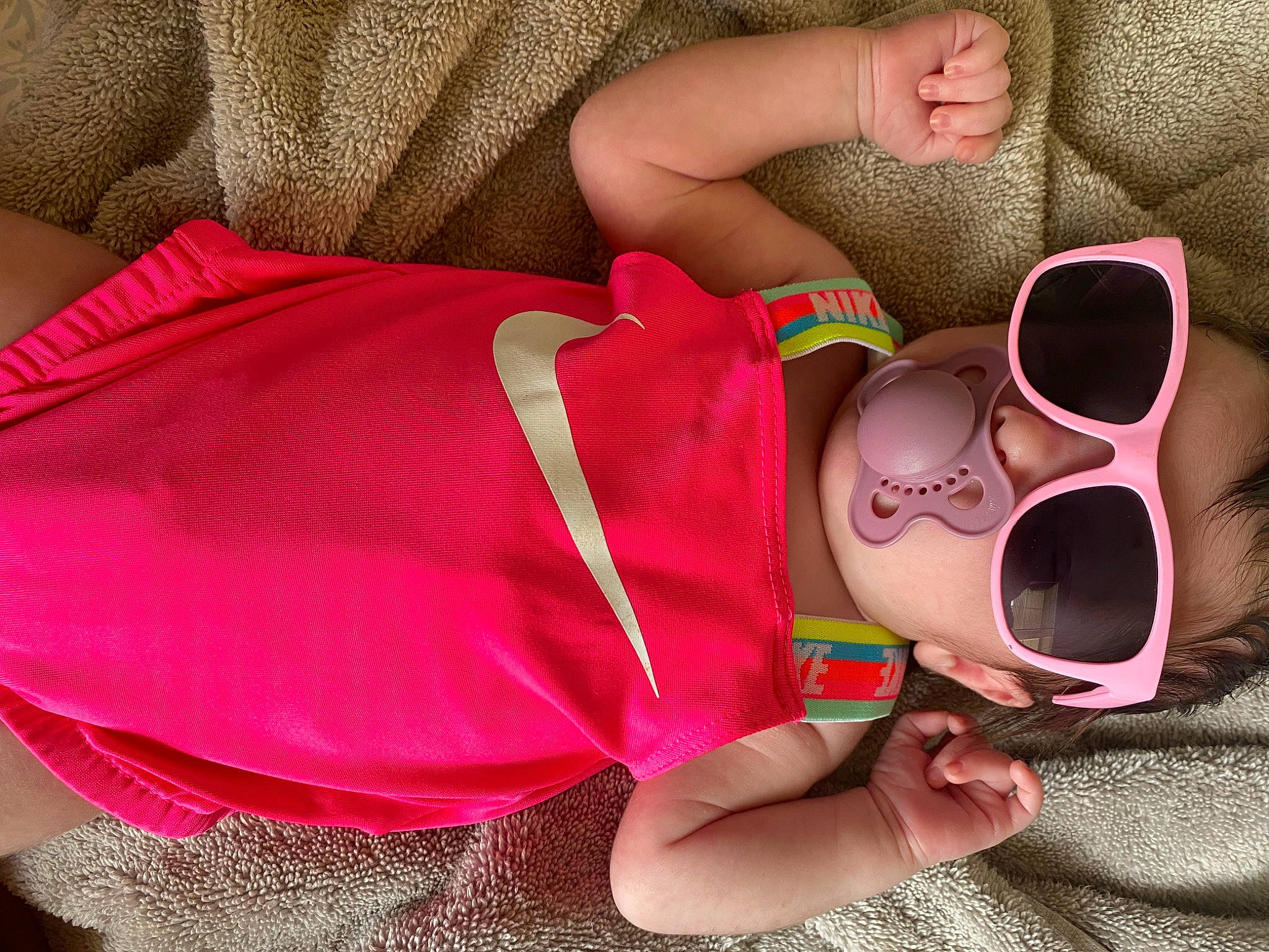 Adelyn is registered to the contest to win money with this photo: baby, baby_toddler_clothing, child, comfort, cool, eyewear, finger, glasses, goggles, hand, happy, headgear, human_leg, leg, magenta, nail, person, pink, sunglasses, thigh