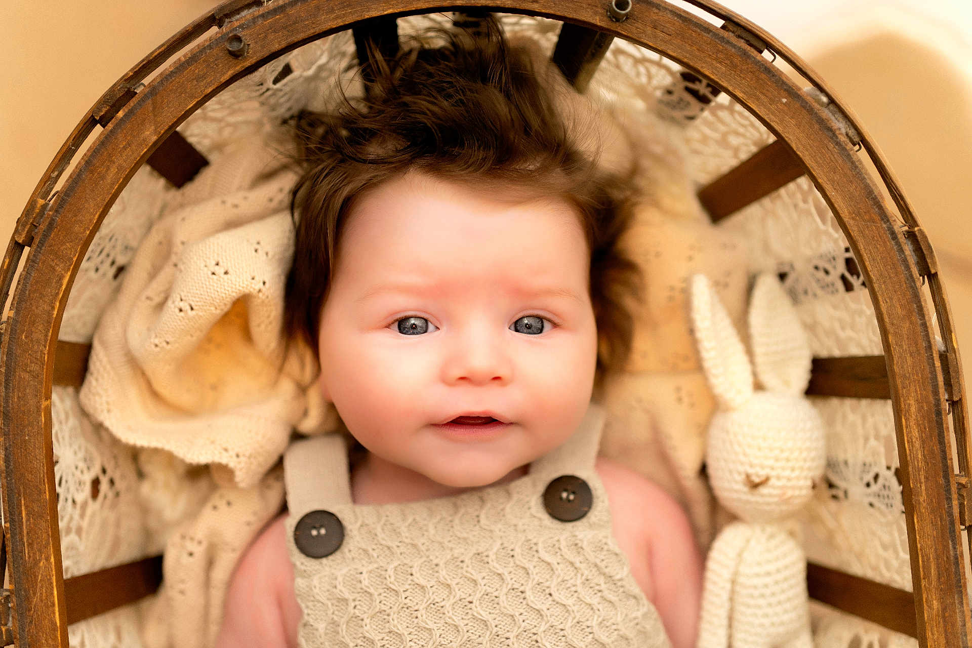 Harper a rejoint le concours — aidez-le/la à gagner de superbes lots ! baby, infant, knitted_blanket, wooden_basket, crocheted_toy, plush_bunny, face, blue_eyes, button_overalls, portrait, cute, soft_lighting, indoors, cozy, newborn, child, smiling, knitwear, warm_colors, sleepy