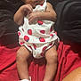 baby, infant, child, headband, strawberry_print, white_sandals, blanket, red_blanket, black_blanket, legs, feet, toes, clothing, relaxing, indoors, person, cute, portrait, baby_girl, toddler