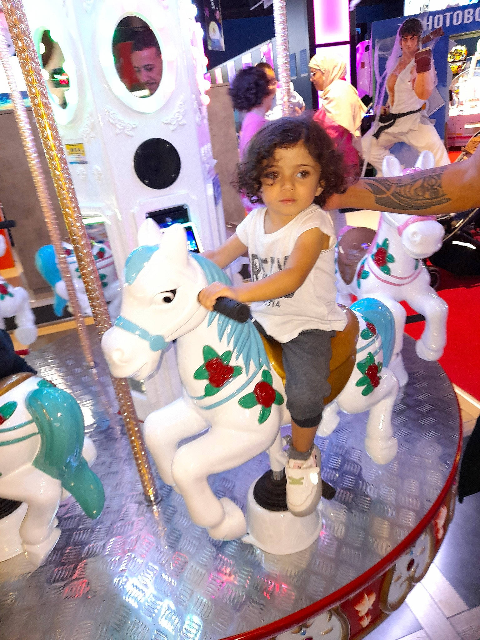Rania participe au concours pour gagner de l'argent avec cette photo : amusement_park, amusement_ride, child, event, fun, games, headwear, horse, leisure, nonbuilding_structure, person, photograph, photography, pink, play, purple, recreation, snapshot, toddler, toy