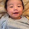 Mung is registered to the contest to win money with this photo: baby, infant, smiling, face, eyes, clothing, blanket, lying_down, cozy, cute, child, portrait, young, warm, indoors, soft_texture, head, expression, happy, baby_garment