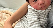 Mung is registered to the contest to win money with this photo: baby, child, striped_pajamas, infant, person, arm, hand, blanket, indoor, comfort, soft, sleepwear, resting, cute, portrait, face, skin, hair, holding, closeup