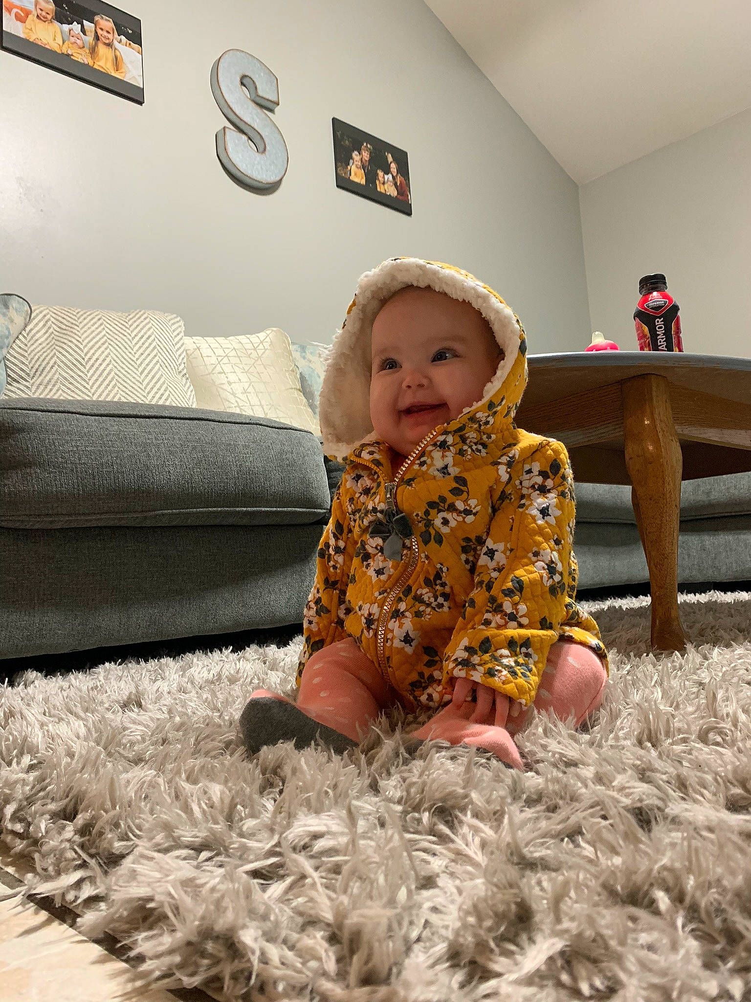 Lynnlie is registered to the contest to win money with this photo: baby, baby_toddler_clothing, bedding, child, comfort, couch, floor, flooring, fun, grass, happy, headwear, joy, linens, living_room, person, picture_frame, room, sitting, smile