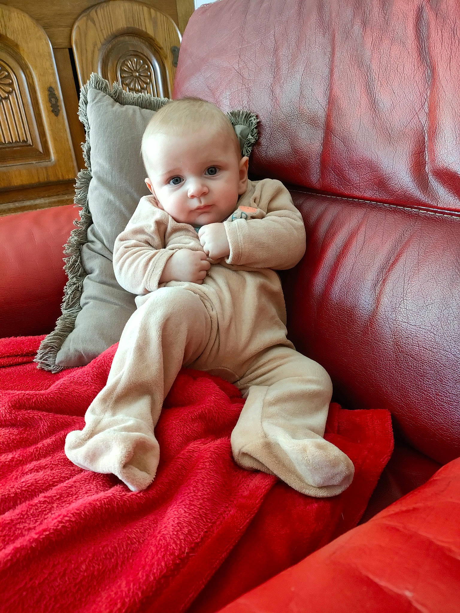 Théo participe au concours pour gagner de l'argent avec cette photo : baby, baby_toddler_clothing, cheek, comfort, eye, floor, flooring, foot, head, human_body, human_leg, knee, lap, leg, linens, person, sitting, skin, textile, toddler