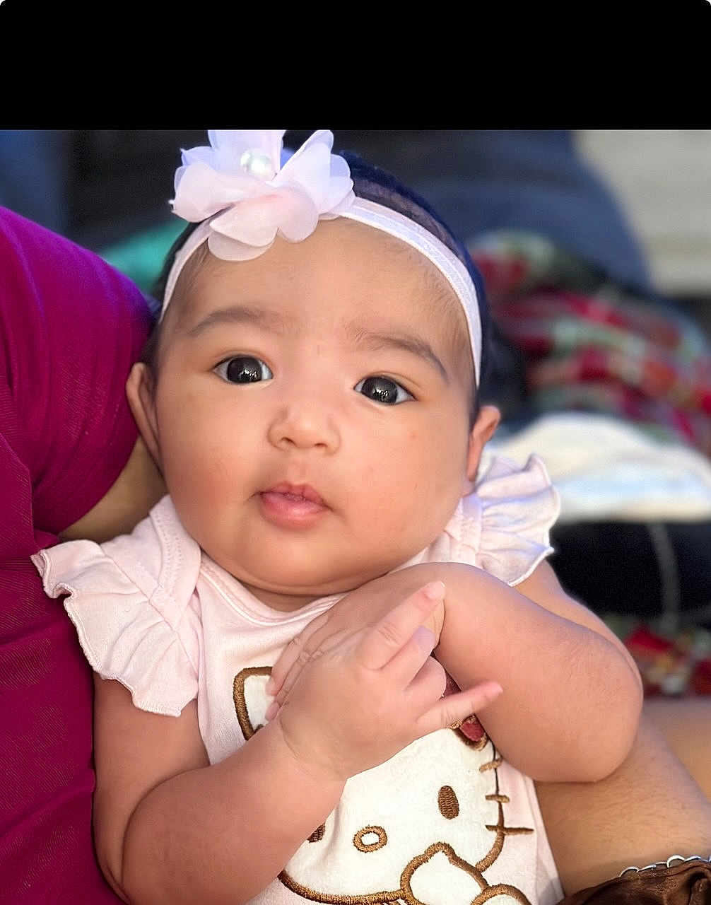 Leilani joined the competition — help win amazing prizes! baby, infant, child, cute, headband, flower, pink_clothing, hello_kitty, arm, hand, face, eyes, person, portrait, soft_light, blurred_background, holding, skin, expression, closeup