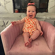 Trinity joined the competition — help win amazing prizes! baby, child, pink_bow, strawberry_pattern, pink_chair, smiling, happy, indoor, plush_chair, cute, sitting, person, infant, toddler, clothing, fun, joy, small_person, armchair, reaching_out