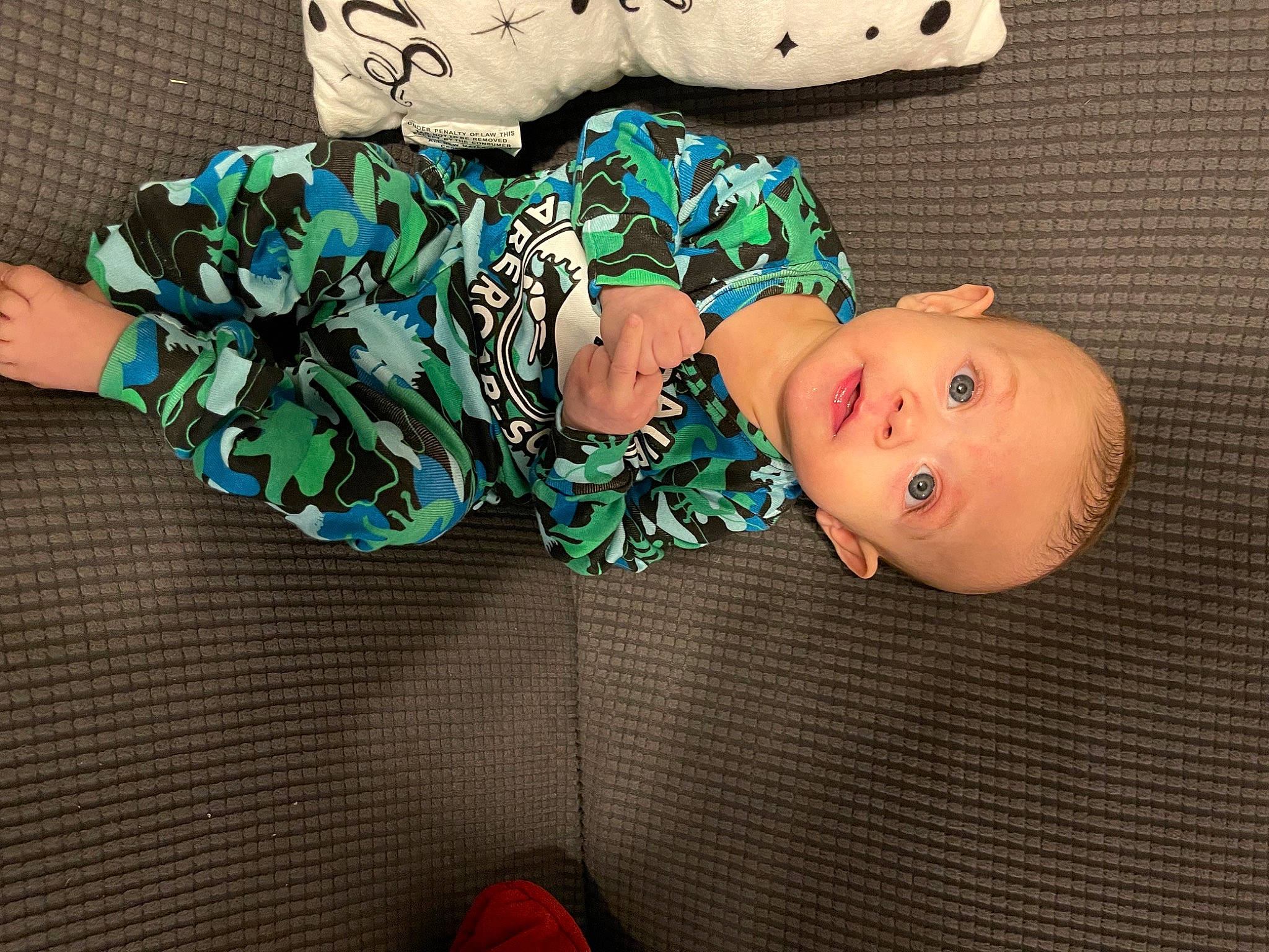 Luka is registered to the contest to win money with this photo: baby, baby_products, baby_toddler_clothing, cheek, child, comfort, fashion_accessory, hat, head, headgear, human_body, pattern, person, sitting, sleeve, surprise, thigh, toddler