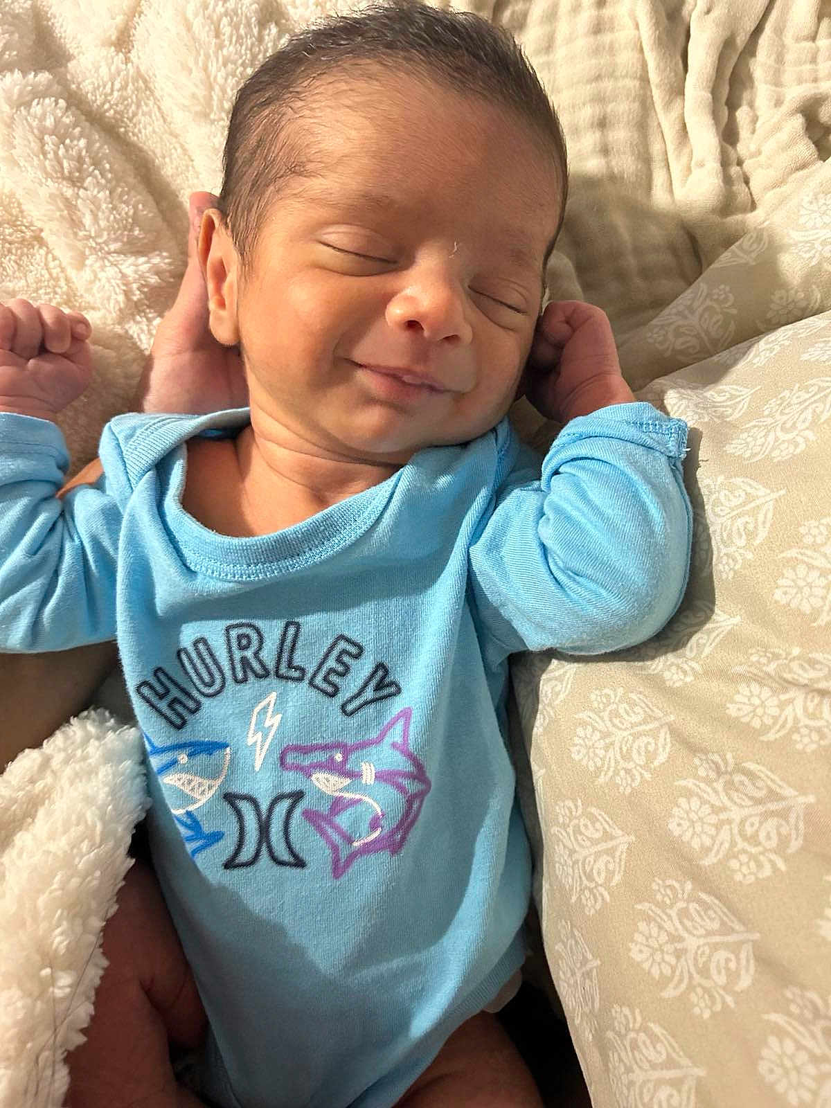 Alexander Appolo is registered to the contest to win money with this photo: baby, baby_clothes, blanket, blue_onesie, clothing, cozy, cute, face, hand, head, human, indoor, infant, newborn, portrait, resting, skin, sleeping, smile, soft