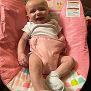 Lakelynn Lawrence joined the competition — help win amazing prizes! baby, bouncer_seat, bright_colors, cute, face, floral_design, hand, happy, indoors, infant, legs, onesie, patterned_fabric, pink, portrait, smiling, soft_fabric, sticker, warning_label, white_sock