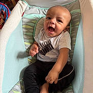 Jabari joined the competition — help win amazing prizes! baby, smiling, sitting, baby_seat, clothing, puma, shirt, pants, barefoot, indoor, happy, child, infant, cute, face, person, foot, hand, cushion, comfort