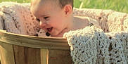 Allison joined the competition — help win amazing prizes! baby, basket, blanket, child, cute, face, grass, happy, knitted, laughter, outdoor, person, plush, portrait, smile, soft_focus, wood, wooden_basket, young_child, natural_light