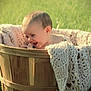 baby, basket, blanket, child, cute, face, grass, happy, knitted, laughter, outdoor, person, plush, portrait, smile, soft_focus, wood, wooden_basket, young_child, natural_light