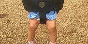 Zamaya is registered to the contest to win money with this photo: toddler, child, swing, playground, smiling, denim_overalls, striped_shirt, shoes, socks, wood_chips, trees, outdoor, happy, fun, play, daylight, park, young_child, baby, person