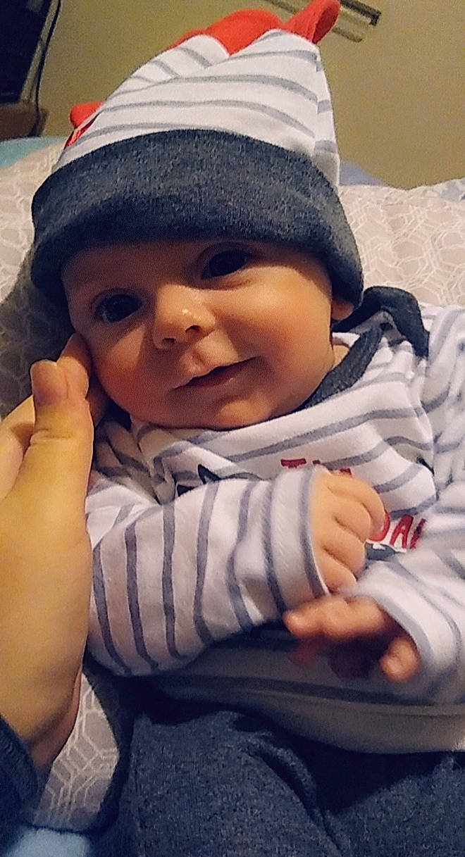 Aiden is registered to the contest to win money with this photo: cap, cheek, comfort, eye, finger, gesture, hand, happy, head, headwear, lip, mouth, nose, organ, outerwear, person, photograph, skin, sleeve, smile