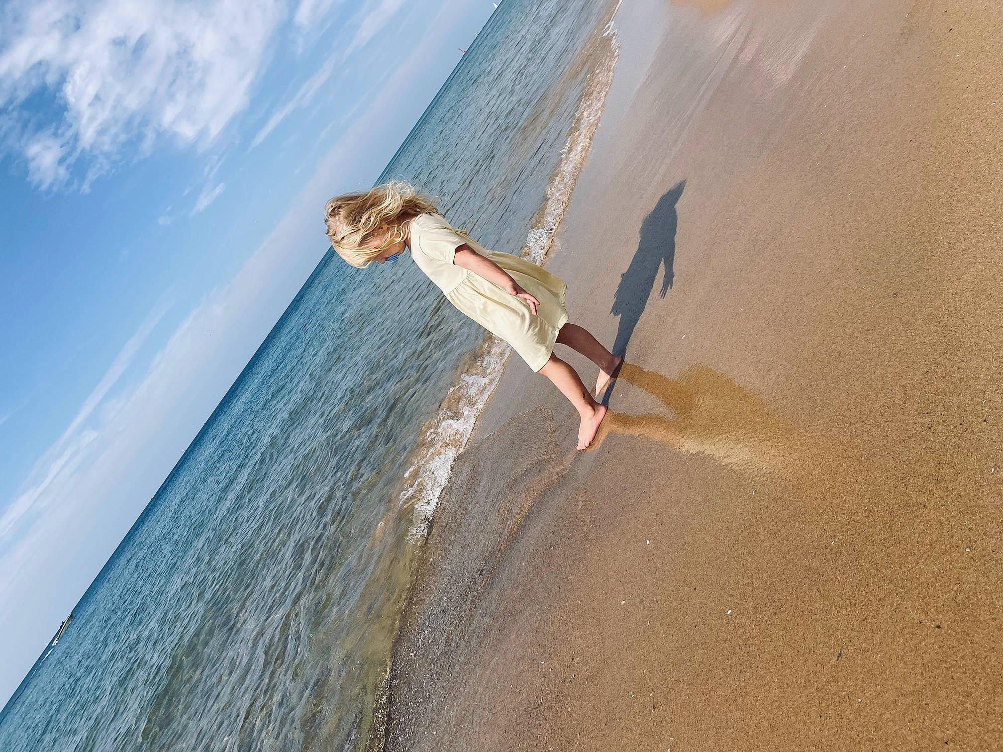 Harper is registered to the contest to win money with this photo: arm, azure, beach, body_of_water, cloud, coastal_and_oceanic_landforms, flash_photography, hand, happy, horizon, human_body, lake, leg, leisure, people_in_nature, people_on_beach, person, sky, surfing_equipment, water