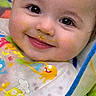 Bella joined the competition — help win amazing prizes! baby, bib, bib_pattern, cheek, close_up, clothing, drool, eyelashes, eyes, face, feeding, food_on_face, happy, highchair, infant, infant_food, mealtime, messy, sitting, smile