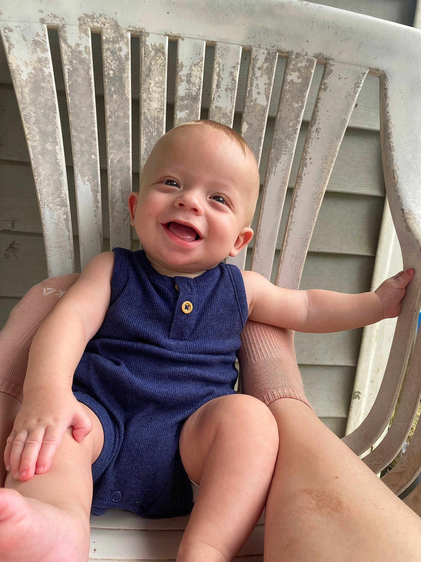 Kashtyn joined the competition — help win amazing prizes! baby, smiling, child, romper, plastic_chair, arm, leg, happy, sitting, outdoor, wooden_wall, face, skin, tooth, expression, cute, infant, person, casual, joyful