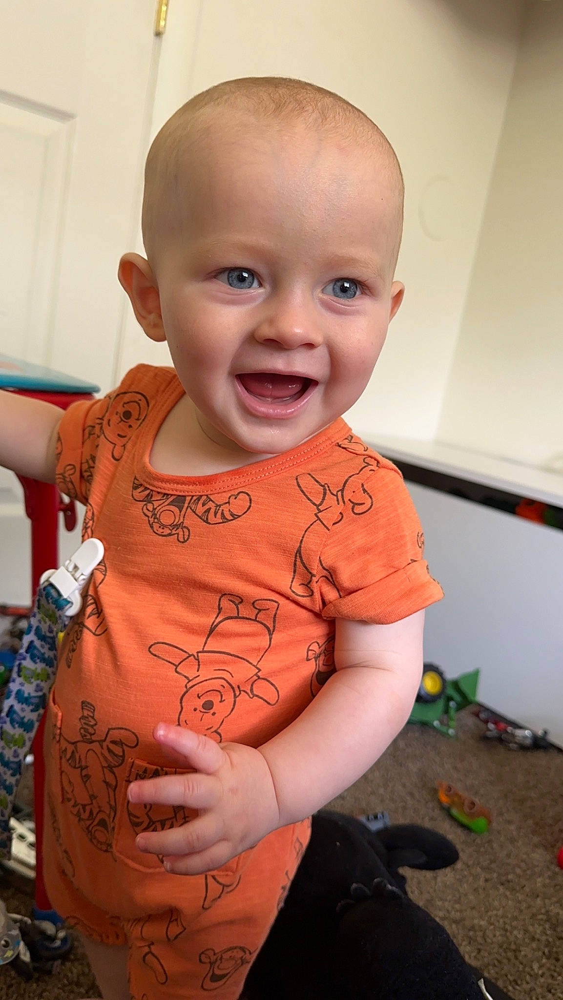 Kaisyn is registered to the contest to win money with this photo: baby, baby_toddler_clothing, cheek, child, face, finger, flooring, fun, happy, human_body, iris, joy, mouth, nose, person, sitting, skin, sleeve, smile, standing