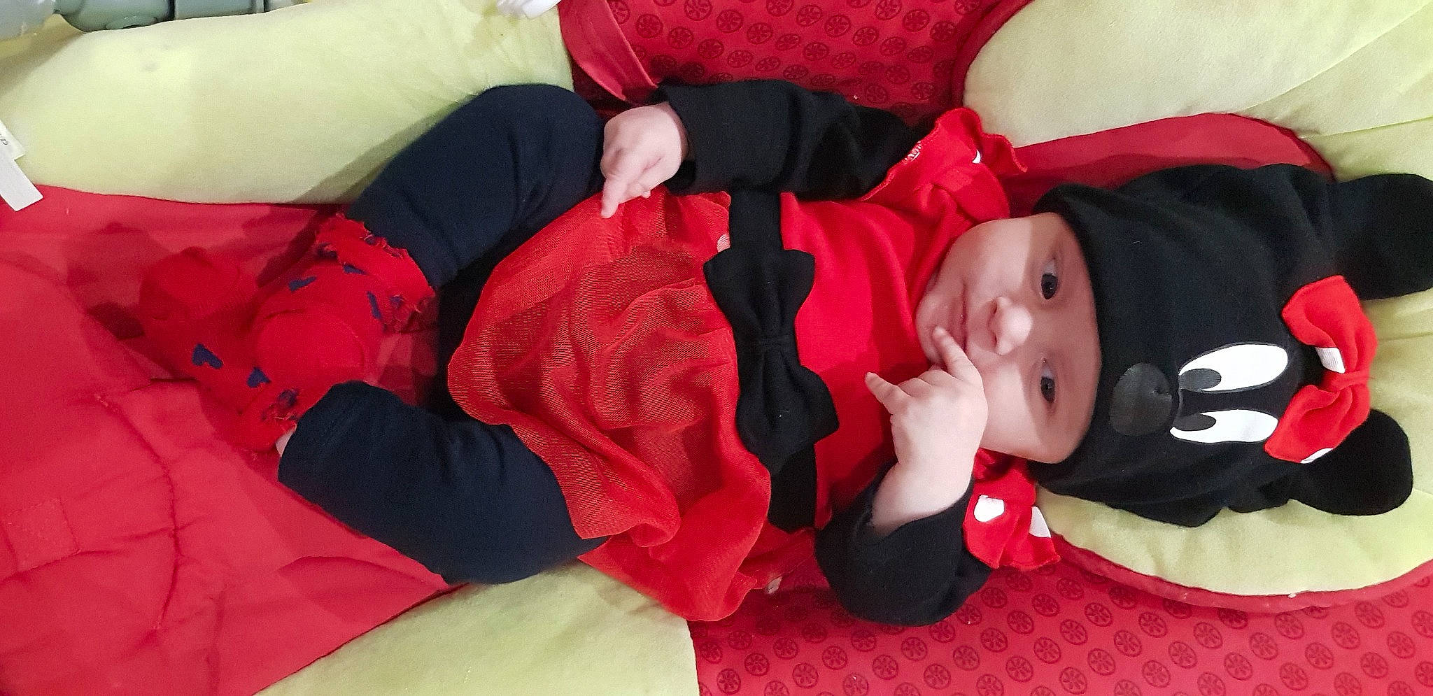 Camille participe au concours pour gagner de l'argent avec cette photo : arm, baby, baby_toddler_clothing, comfort, face, finger, fun, hand, hat, headwear, human_body, lap, leg, mouth, person, pink, red, sleeve, textile, thigh