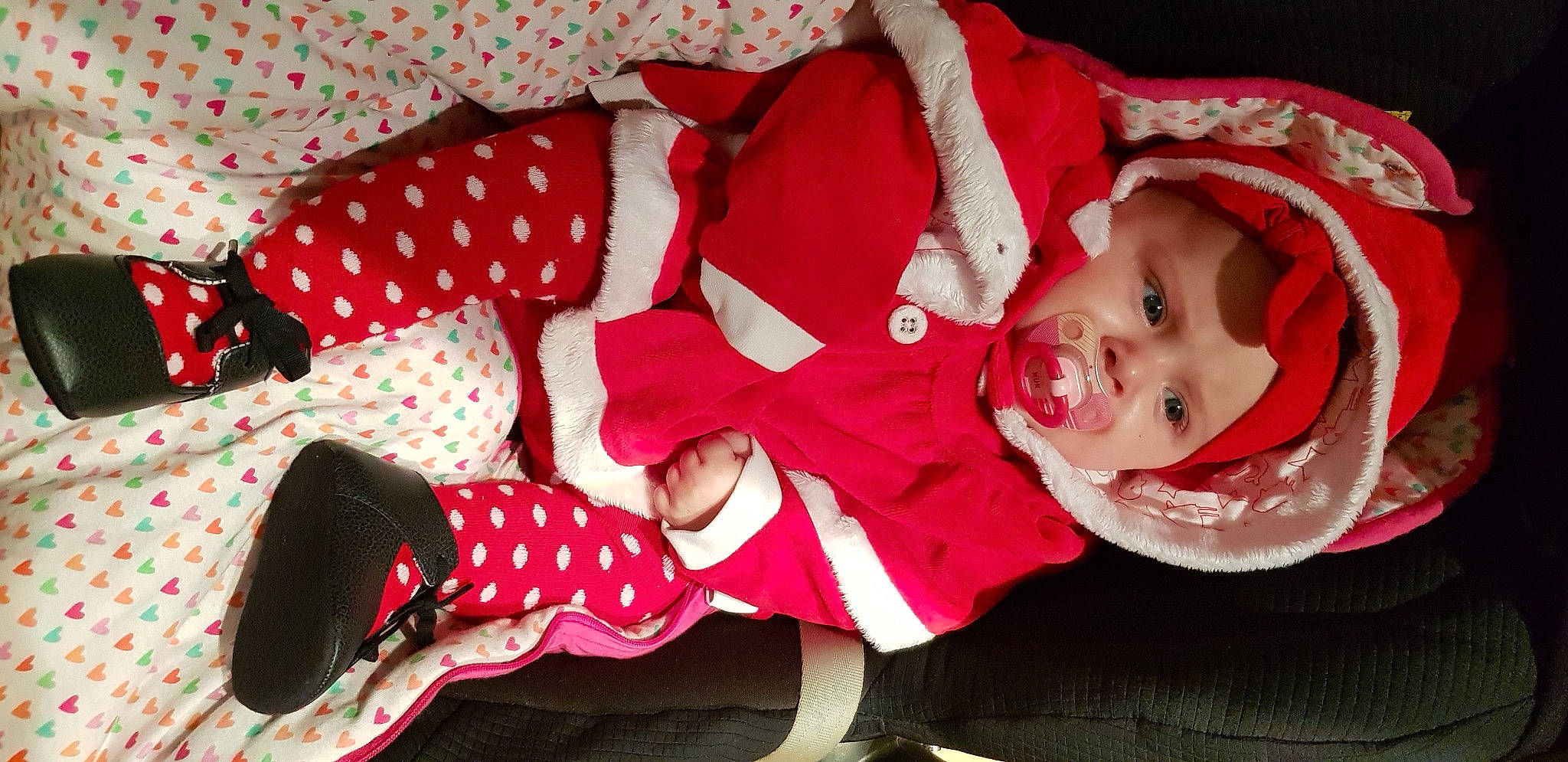 Camille participe au concours pour gagner de l'argent avec cette photo : baby, baby_toddler_clothing, carmine, child, christmas, christmas_eve, costume, event, fictional_character, happy, hat, headwear, holiday, lap, pattern, person, sleeve, smile, sock, textile