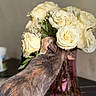 Kitty is registered to the contest to win money with this photo: bouquet, cat, close_up, colorful, curious, decor, domestic_animal, feline, floral_arrangement, flower, indoor, nature, pet, plant, roses, stem, still_life, table, vase, white_flower