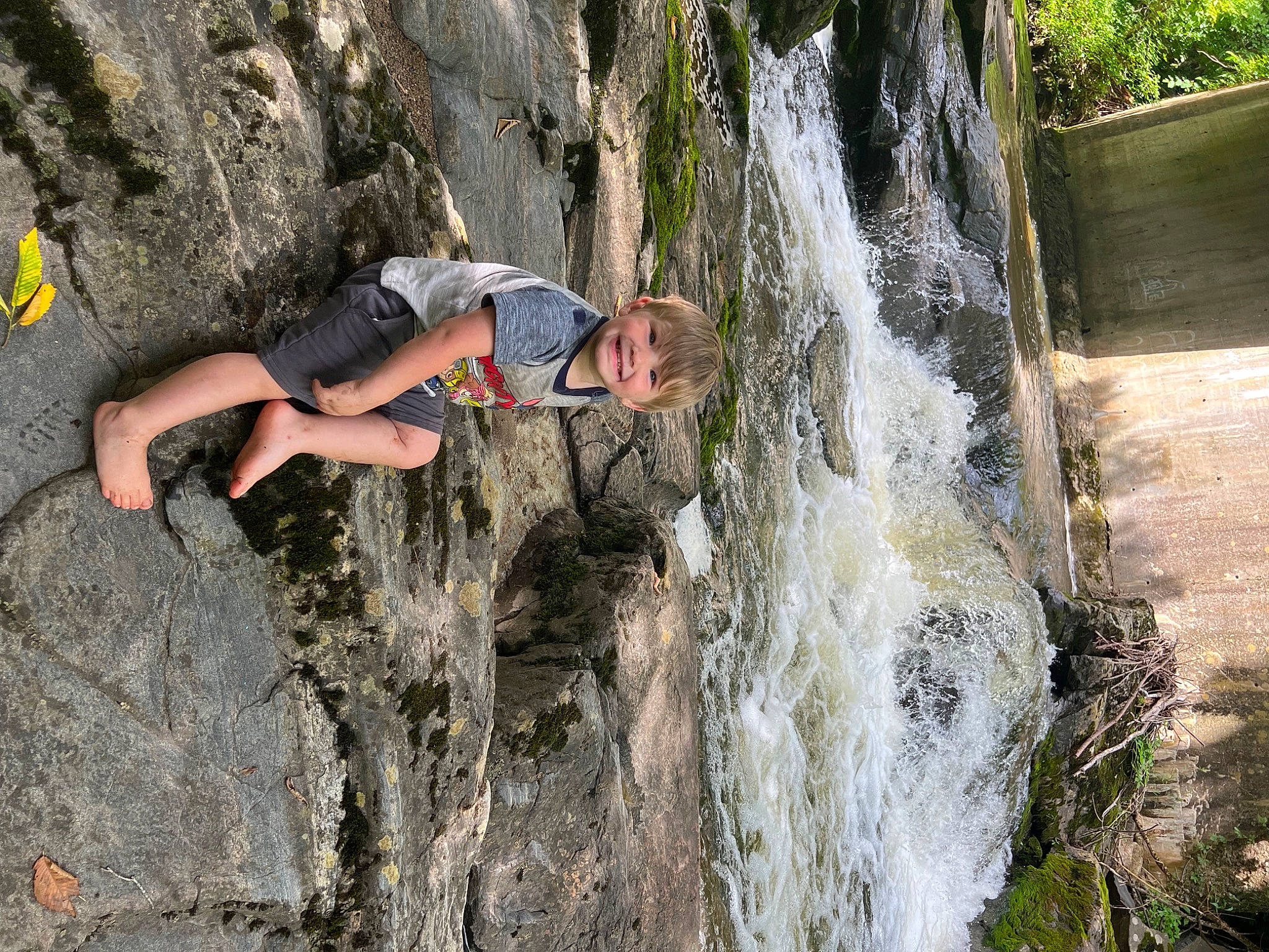 Mathew is registered to the contest to win money with this photo: bedrock, chute, climbing, font, formation, fun, joy, landscape, leisure, outcrop, person, plant, recreation, rock_climbing, rock_climbing_equipment, shorts, sport_climbing, spring, tree, water