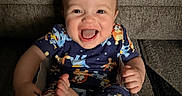 Patrick joined the competition — help win amazing prizes! baby, baby_seat, barefoot, cartoon_clothing, child, colorful, couch, face, feet, hands, happy, home, indoor, infant, laughing, pajamas, portrait, sitting, smiling, sofa
