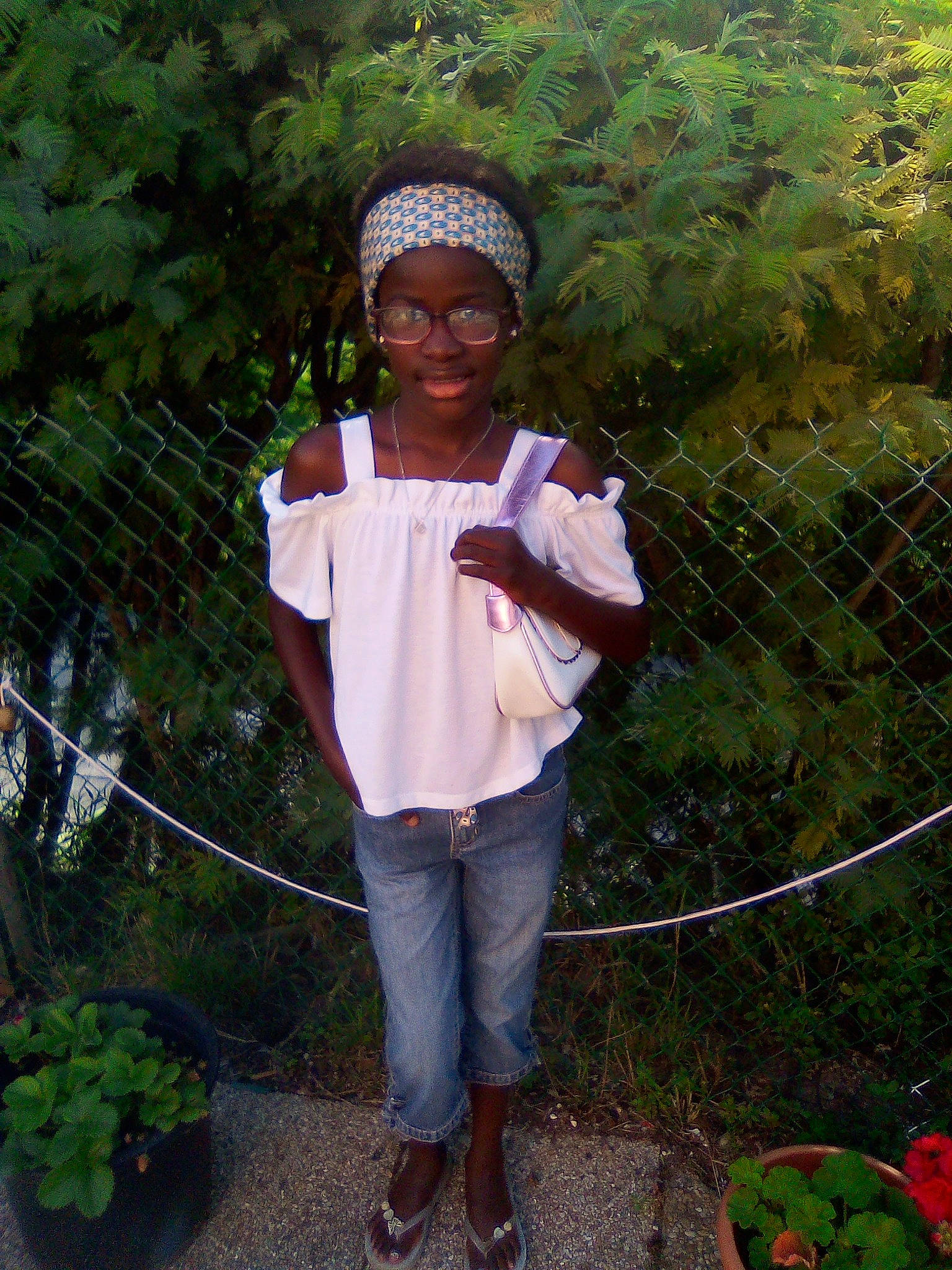 Laura a rejoint le concours — aidez-le/la à gagner de superbes lots ! botany, eyewear, fence, flowerpot, fun, garden, grass, headwear, houseplant, leisure, people_in_nature, person, plant, sandal, shrub, sleeve, smile, soil, t_shirt, tree