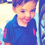 Jerimach is registered to the contest to win money with this photo: child, boy, smile, blue_shirt, outdoor, daylight, cars, parking_lot, holding_card, short_hair, young, face, cheeky, tongue_out, casual_clothing, polo_shirt, sunlight, happy, person, portrait
