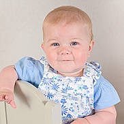 Avery joined the competition — help win amazing prizes! baby, child, face, blue_eyes, smile, arm, chair, overalls, blue_shirt, light_skin, short_hair, portrait, cute, indoor, person, infant, baby_clothing, expression, young_child, background