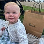baby, child, outdoor, park, blanket, cardigan, dress, shopping_bag, stroller, grass, lake, waterfowl, people, sneakers, nature, trees, daytime, cute, portrait, happy