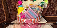 Royce'Lynn is registered to the contest to win money with this photo: child, girl, smiling, basket, toys, couch, dress, white_bow, indoor, happy, face, legs, patterned_pillows, fabric, colorful, holding, seated, home, cute, playful