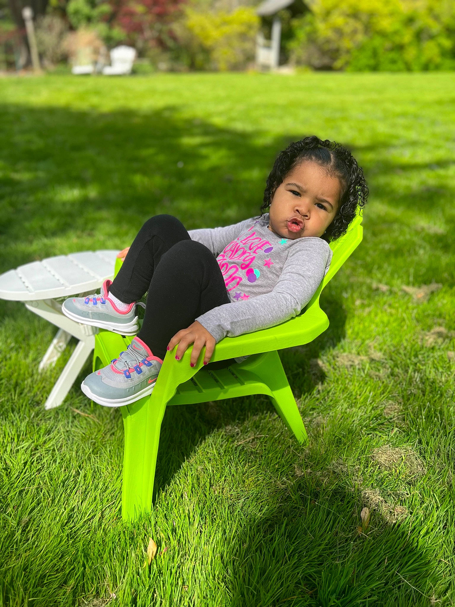 Leilanni is registered to the contest to win money with this photo: chair, child, fun, grass, grassland, green, happy, lawn, leaf, leisure, magenta, people_in_nature, person, plant, recreation, sitting, spring, t_shirt, thigh, toddler