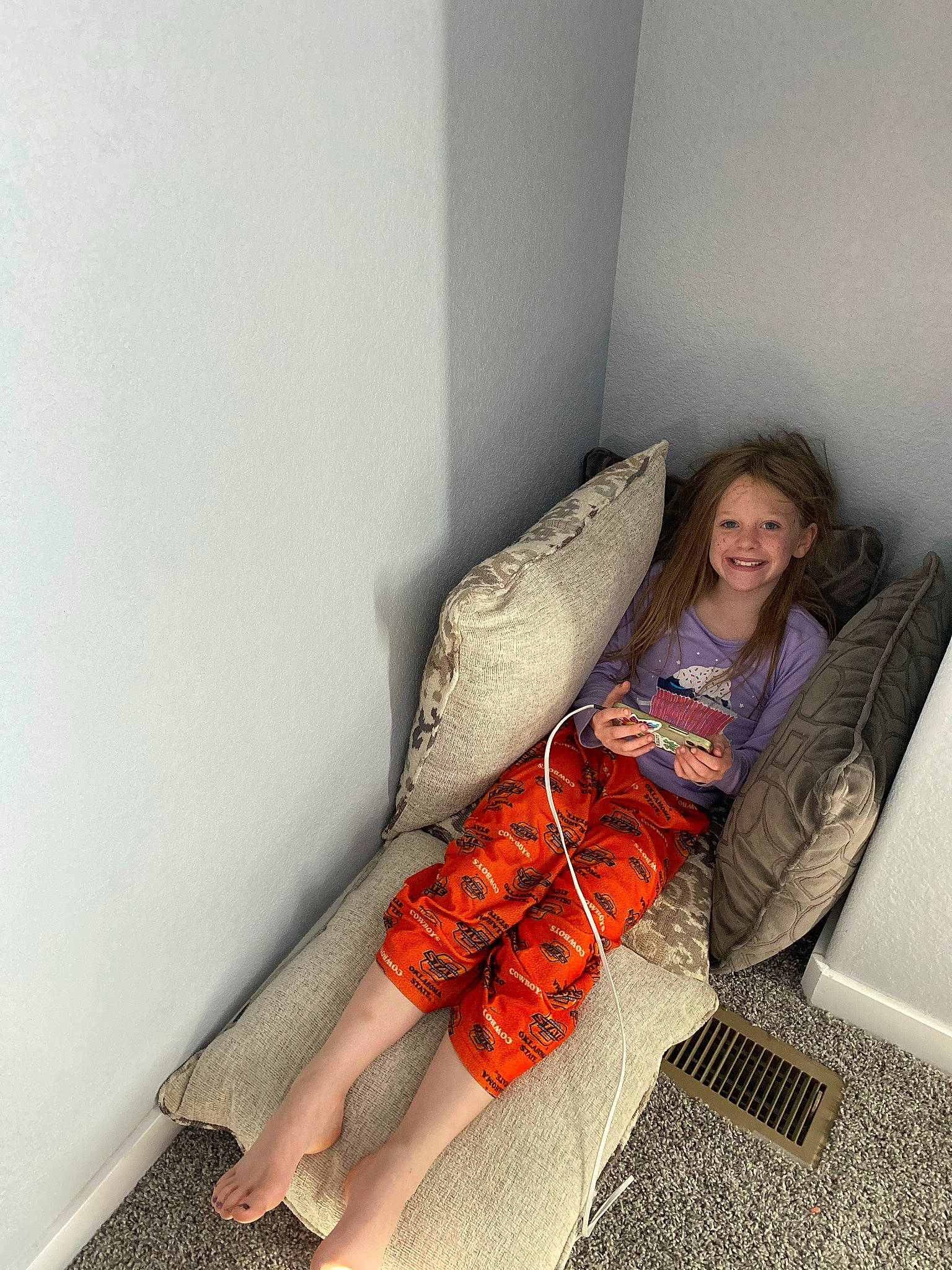 Kennedy is registered to the contest to win money with this photo: bag, barefoot, bedding, comfort, fashion_accessory, floor, flooring, foot, hardwood, human_leg, joy, knee, linens, luggage_and_bags, nap, person, room, selfie, sitting, smile