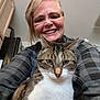 woman, cat, indoor, smile, glasses, tabby_cat, kitchen, plaid_shirt, person, pet, feline, happy, face, animal, portrait, home, closeup, domestic, friendly, cozy