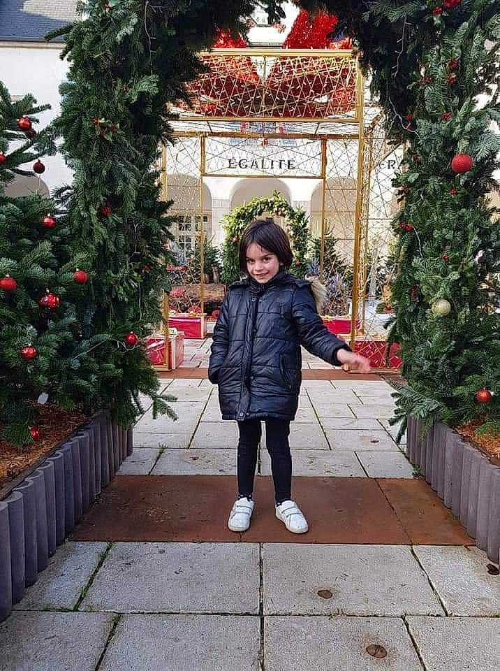 Gabriella a rejoint le concours — aidez-le/la à gagner de superbes lots ! christmas, christmas_decoration, event, facade, flooring, grass, holiday, house, jacket, joy, leisure, line, ornament, pedestrian, person, plant, red, standing, street, street_fashion
