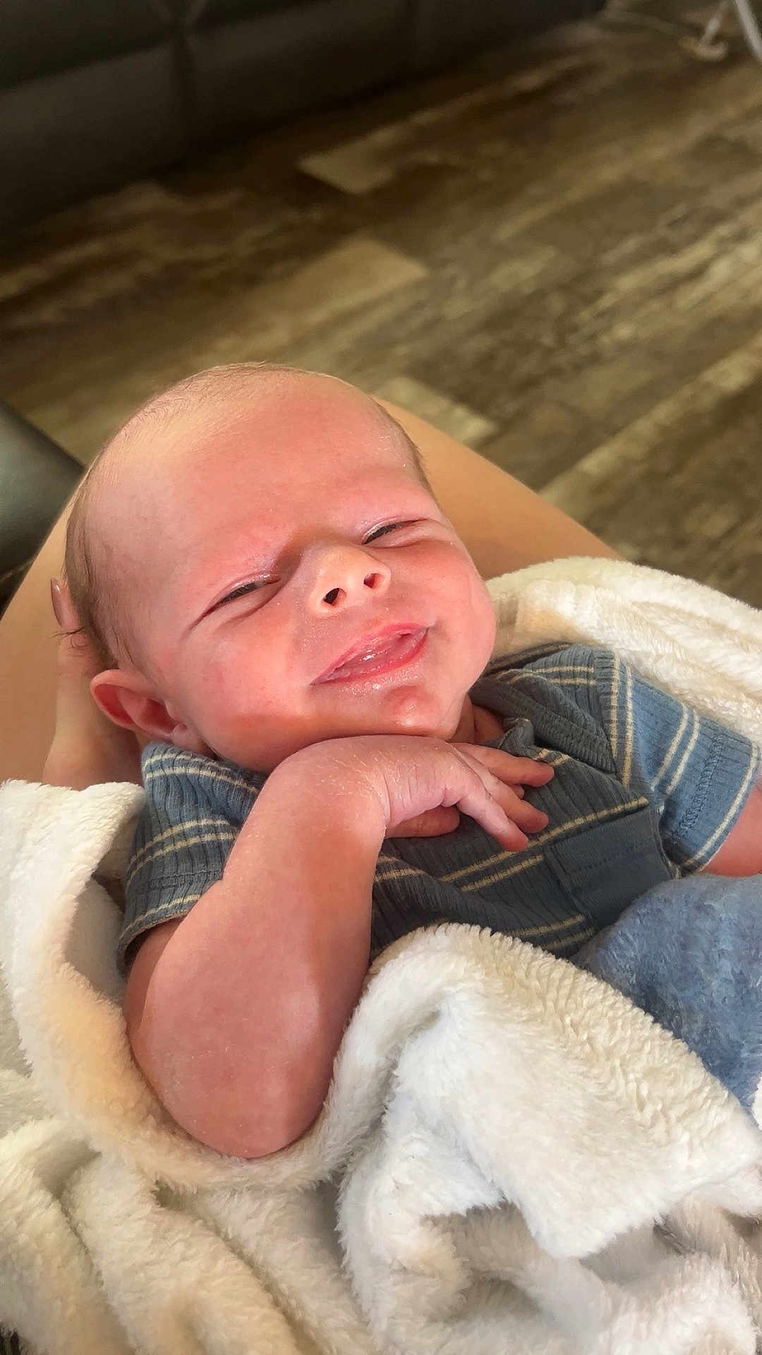Agon joined the competition — help win amazing prizes! baby, newborn, smile, blanket, hand, face, person, clothing, blue_shirt, skin, indoor, floor, comfort, cute, infant, portrait, resting, human, warmth, soft