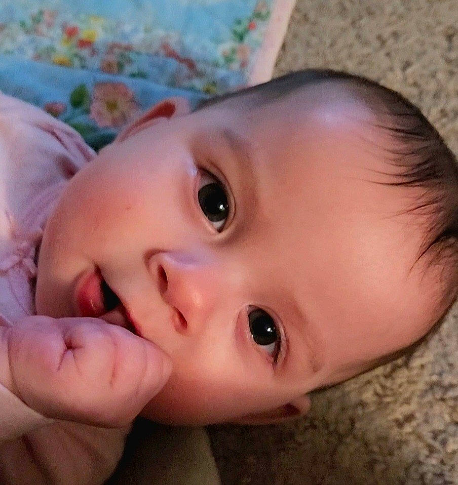 Ada is registered to the contest to win money with this photo: baby, cheek, close_up, eye, eyebrow, eyelash, finger, forehead, gesture, grass, happy, human_body, iris, lip, mouth, nose, person, skin, smile, toddler