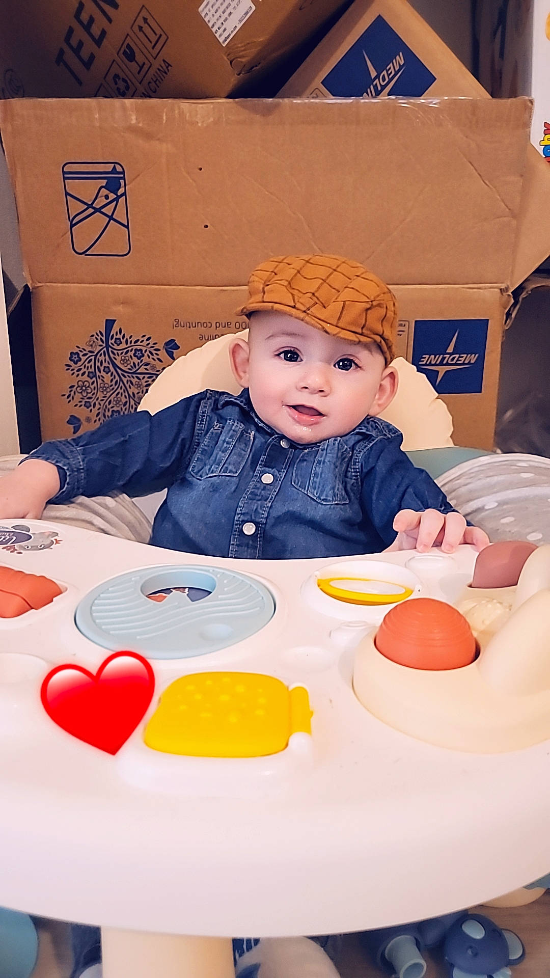 Cameron a rejoint le concours — aidez-le/la à gagner de superbes lots ! baby, chair, child, event, facial_expression, fun, hat, headwear, human, leisure, orange, party_supply, person, plate, product, recreation, sitting, sun_hat, table, tableware