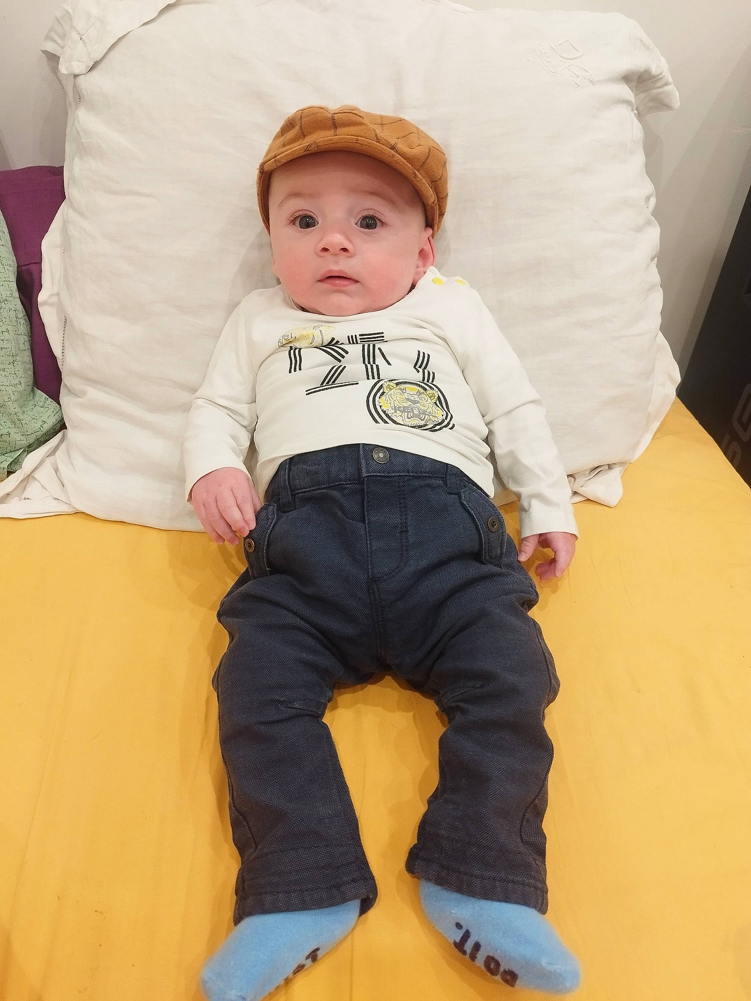Cameron a rejoint le concours — aidez-le/la à gagner de superbes lots ! baby, baby_toddler_clothing, barefoot, cheek, child, comfort, couch, eye, flooring, happy, head, headwear, knee, linens, person, room, sitting, sleeve, t_shirt, textile