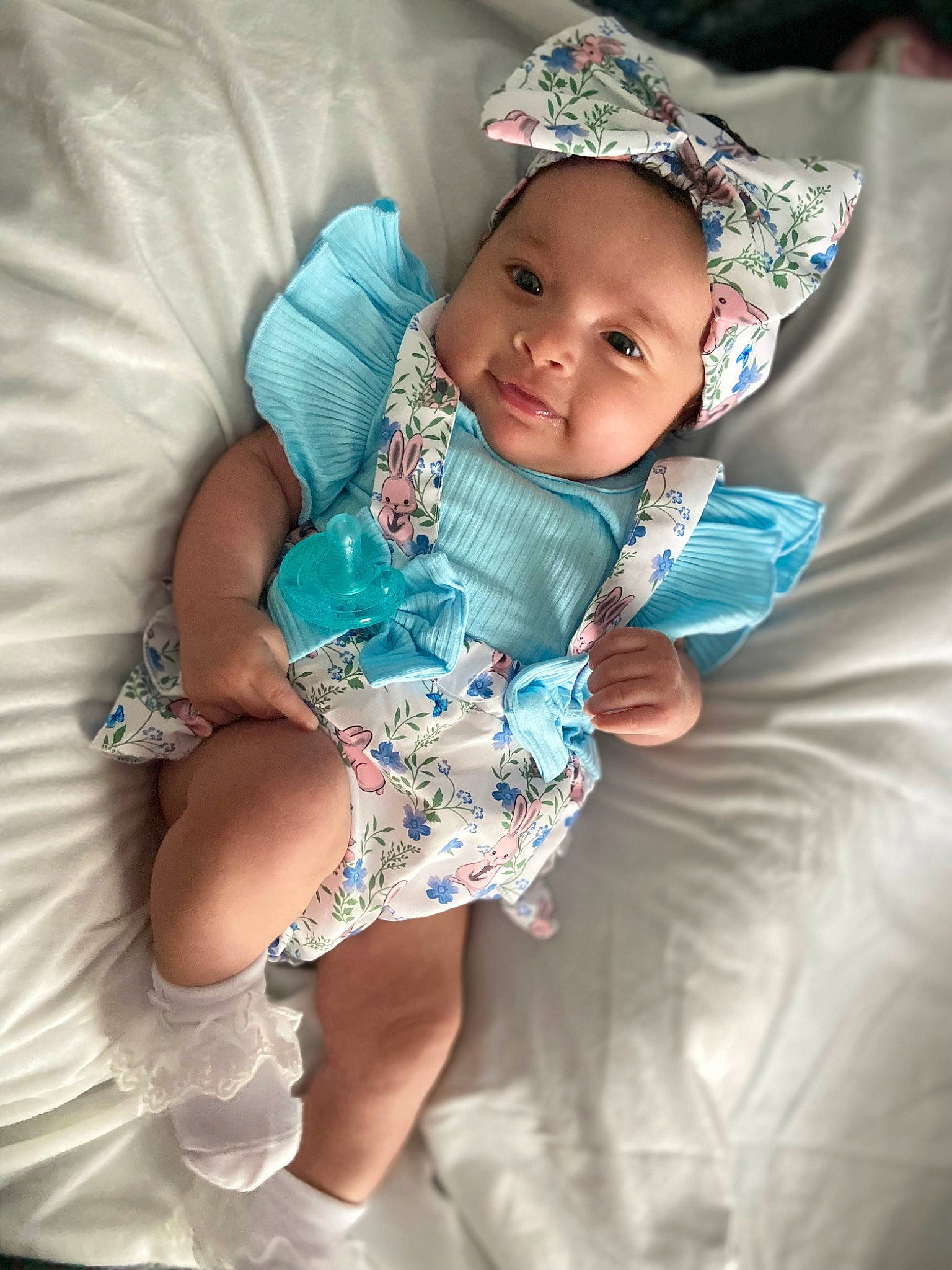 Annalise is registered to the contest to win money with this photo: arm, baby, baby_toddler_clothing, cheek, child, comfort, eye, face, finger, hand, happy, head, headwear, linens, mouth, person, purple, skin, sleeve, smile