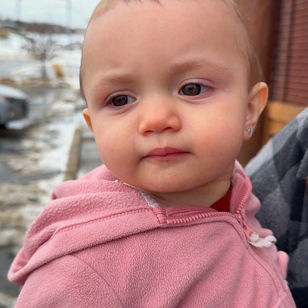 Zayla is registered to the contest to win money with this photo: casual, child, closeup, clothing, cold_weather, curious, daylight, earrings, expression, face, fleece, head, outdoor, person, pink_jacket, portrait, snow, toddler, winter, young_child