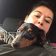Duchess joined the competition — help win amazing prizes! woman, dog, pet, cuddle, indoor, car, seat, portrait, face, animal, closeup, black, brown, jacket, head, eyes, nose, ear, comfort, casual