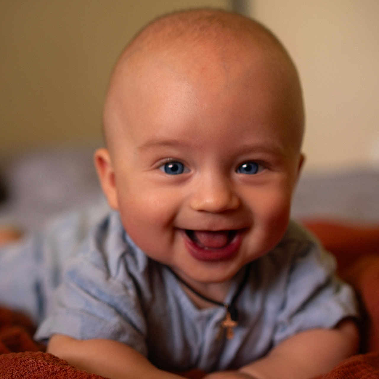 Lucas joined the competition — help win amazing prizes! baby, infant, smile, happy, blue_eyes, blanket, cute, portrait, child, face, skin, lying_down, indoors, cozy, expression, person, head, clothing, necklace, warm_colors