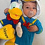 baby, blue, child, costume, cute, donald_duck, face, hand, hood, indoor, infant, pacifier, person, plush_toy, portrait, red, smile, soft_toy, white, yellow