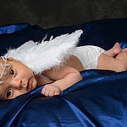 Elyes a rejoint le concours — aidez-le/la à gagner de superbes lots ! angel_wings, baby, blanket, blue_satin, costume, cute, diaper, expression, face, feet, hand, headband, infant, lying_down, newborn, portrait, skin, sleeping_area, soft_lighting, studio
